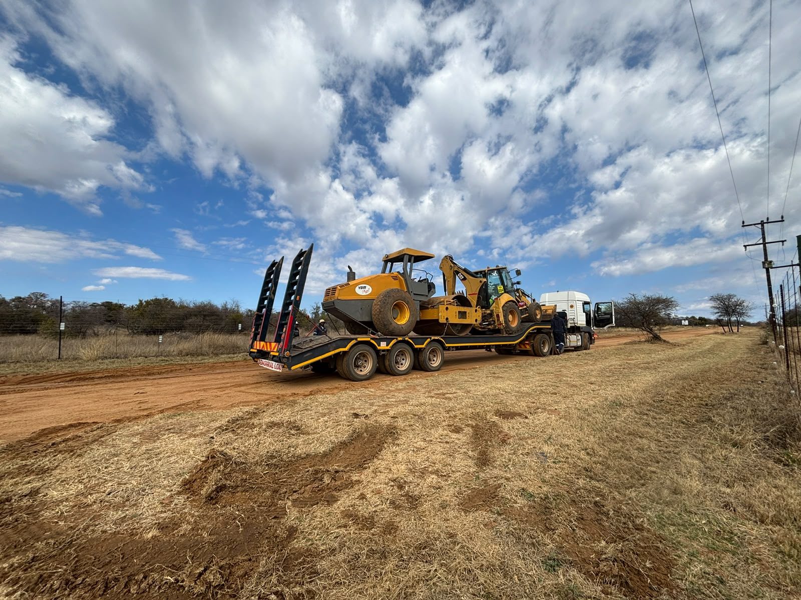 Roller and backhoe loader on an abnormal-load trailer
