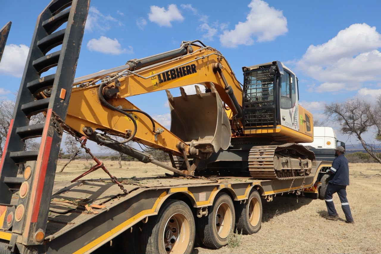 Excavator secured on a low-bed trailer