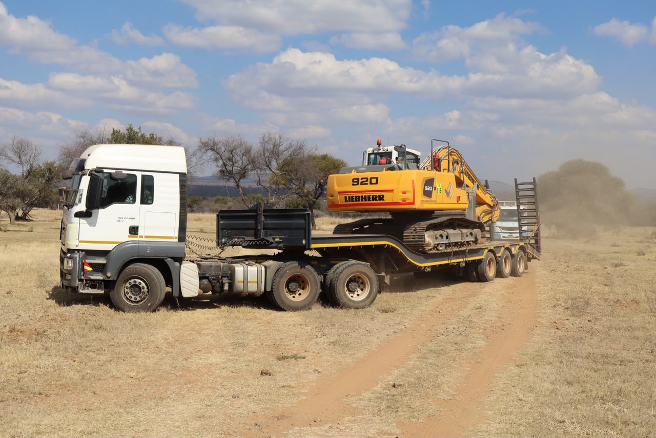 RhinoLink truck transporting a heavy excavator